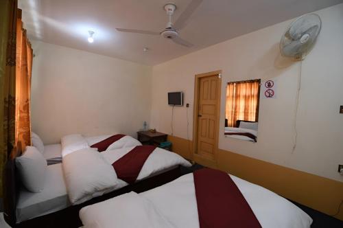 a hotel room with two beds and a fan at Heaven Hotel Skardu in Skardu