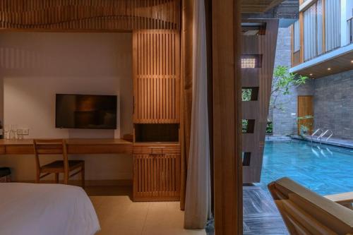 a bedroom with a bed and a television and a swimming pool at Mai's Boutique in Da Nang