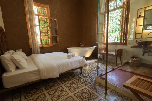 a bedroom with a large bed and a bath tub at Beit Toureef in Beirut