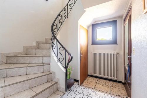 a hallway with stairs and a door with a window at Spacieux T3 Parking FREE WIFI Haut-Débit in Magland