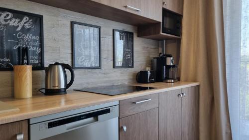 a kitchen with a counter top with a coffee maker at Q Apart Meta -1, 2 lub 3-pokojowe, klimatyzowane apartamenty przy Manufakturze z garażem lub parkingiem Gratis, FV in Łódź