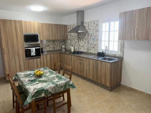 a kitchen with a table with a fruit bowl on it at Casita 7 Islas in Giniginámar