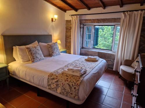 een slaapkamer met een groot bed en een raam bij Casa de Sao Miguel Douro in Armamar