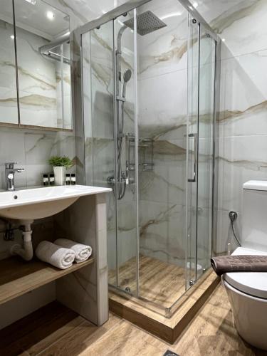 a bathroom with a glass shower and a sink at Utopia.luxuryapartment in Nea Potidaea