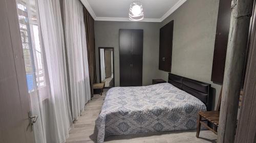Schlafzimmer mit einem Bett und einem Fenster in der Unterkunft Guest House NINI in Bordschomi
