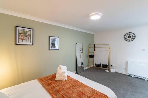 a bedroom with a bed and a clock on the wall at 17 Bowline · Superb Studio Free Parking Pass the Keys in Hartlepool