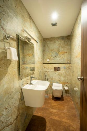 a bathroom with a sink and a toilet at Hybiz by Darshan in Anchal
