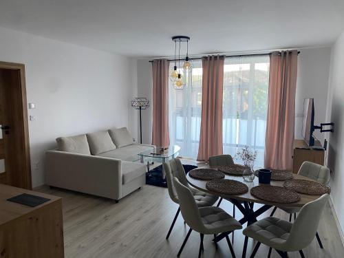 Una sala de estar con un sofá, una mesa y sillas. en Airappartment trojizbový byt, en Bardejov