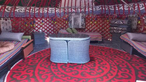 a room with a red carpet with a wicker basket on top of a red at Ak-Tengir Yurt Resort in Tossor