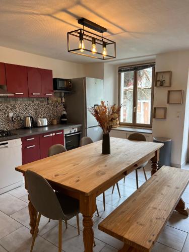 Il comprend une cuisine avec une table et des chaises en bois. dans l'établissement Charmante maison de village à 10min de Thonon-les-Bains, à Allinges