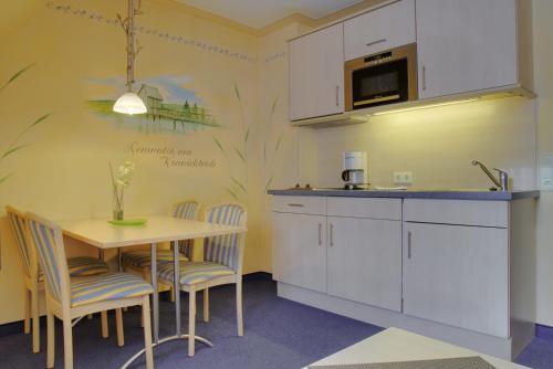 a kitchen with a table and chairs and a microwave at Cafe Steffens in Hahnenklee-Bockswiese