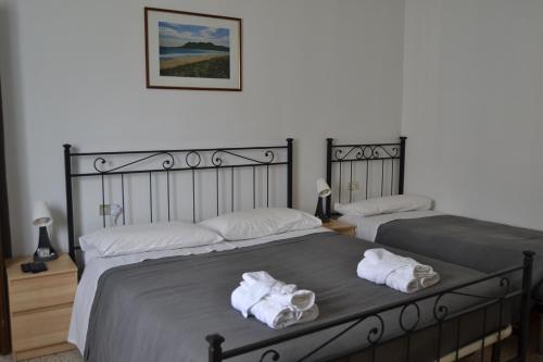 two beds in a bedroom with towels on them at La Rosa e la Spina - Casa Vacanze indipendente con giardino privato - Dervio, Lago di Como in Dervio