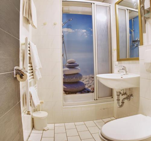 ein Bad mit einem Waschbecken, einem WC und einer Dusche in der Unterkunft Cafe Steffens in Hahnenklee-Bockswiese