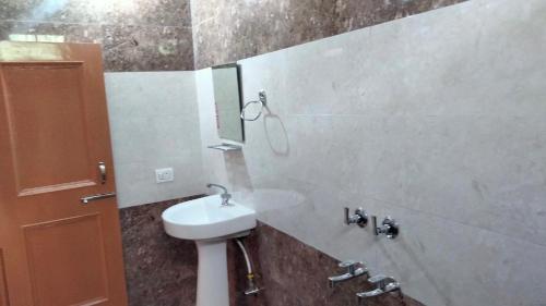 uma casa de banho com um lavatório e um espelho em Happy home stay, Dharamshala em Dharamshala
