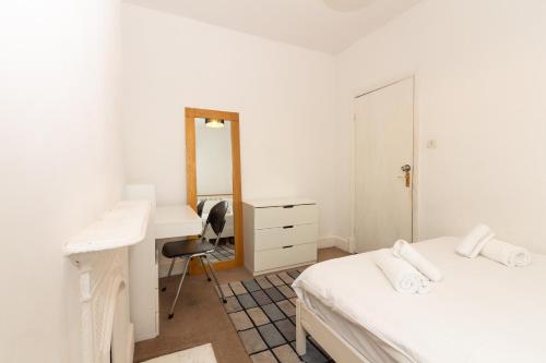 曼徹斯特的住宿－Suite 3 - Trendy Private Room near City Centre，一间卧室配有两张床、一张桌子和一面镜子