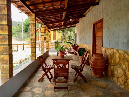 a patio with a table and chairs on a porch at Reserva do Bosque Hospedaria e Natureza in Ibicoara