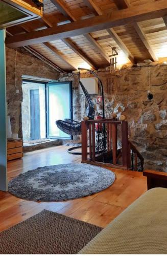 a living room with a chair and a rug at Ninho do Corvo da Urgueira in Urgueira