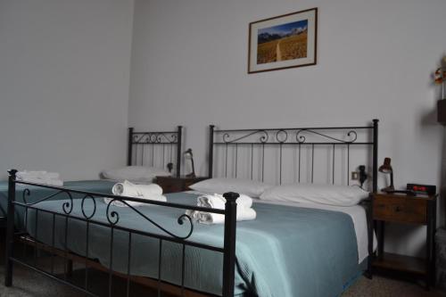 a bedroom with two beds and a picture on the wall at La Rosa e la Spina - Casa Vacanze indipendente con giardino privato - Dervio, Lago di Como in Dervio