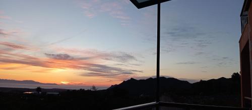 a sunset seen through a window of a building at Summer Villa with sea view,6 min drive from airport, near Seitan Limania beach in Khordhákion