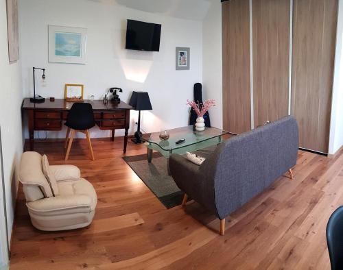a living room with a couch and a table at LE CLOS DES PRAIRIES Suite 2 grandes chambres in Saint-Yan