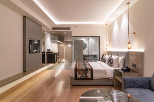 a large bedroom with a bed and a couch at Regenta Place Amritsar by Royal Orchid Hotels Limited in Amritsar