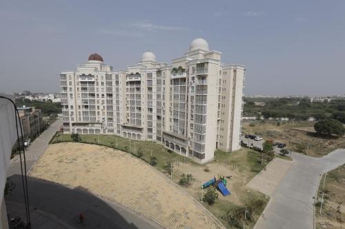 a large white apartment building on the side of a street at Blue Mans Rooms in Vrindāvan