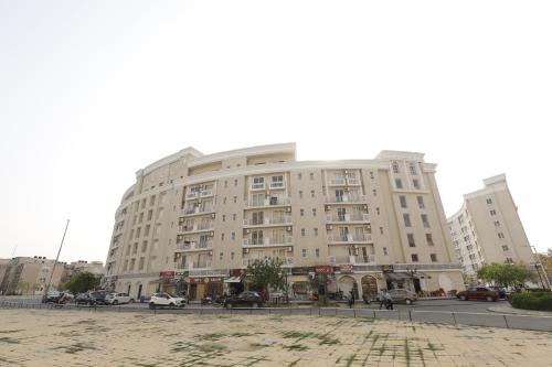 a large building with cars parked in front of it at Blue Mans Rooms in Vrindāvan