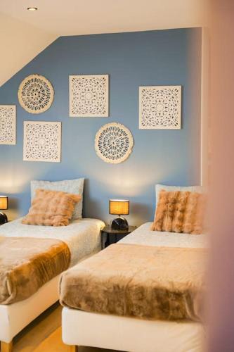 deux lits dans une chambre aux murs bleus dans l'établissement Villa piscine jacuzzi étang ,la casa del cookie 2, à Brognon