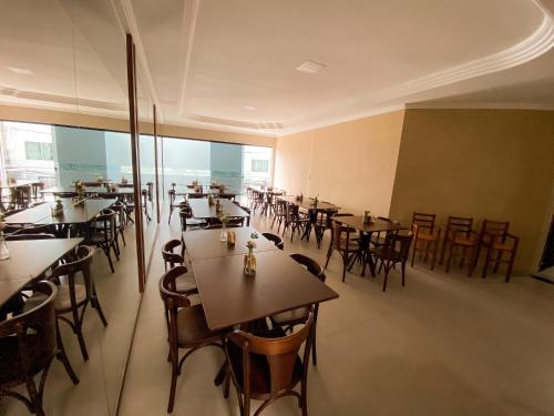 a restaurant with tables and chairs in a room at Hotel Cantinho Verde in Teixeira de Freitas