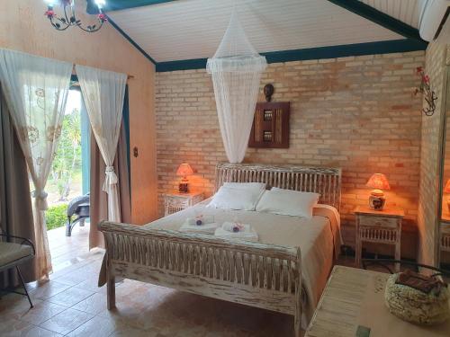 ein Schlafzimmer mit einem großen Bett in einem Zimmer in der Unterkunft Verdes Em Cantos Pousada in Carrancas