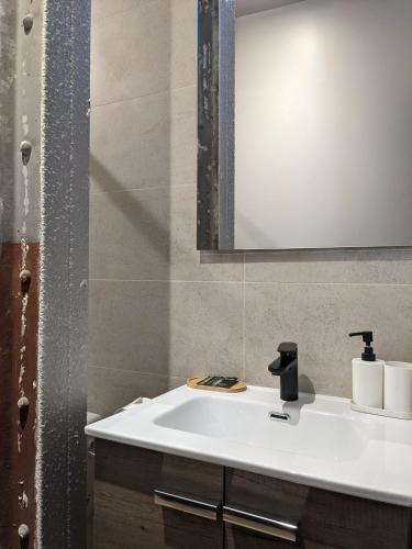 une salle de bain avec un lavabo blanc et un miroir dans l'établissement Le 12 cosy wifi et parking gratuit 7b, à Saint-Étienne