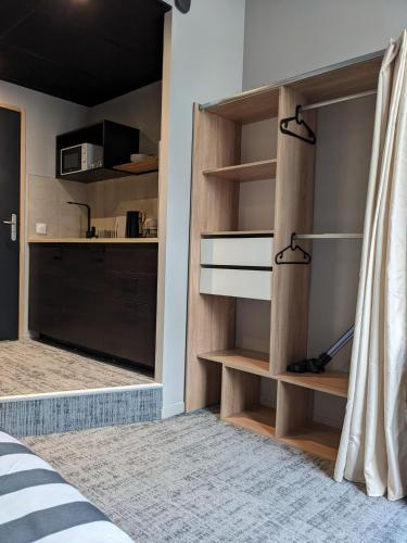 - une chambre avec des étagères en bois et un lit dans l'établissement Le 12 cosy wifi et parking gratuit 7b, à Saint-Étienne