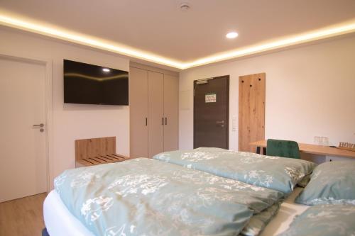 a bedroom with a bed and a table with a television at Engelns-Inn in Hövelhof