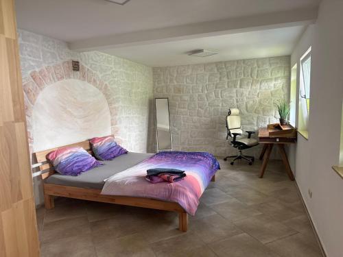 a bedroom with a bed with a stone wall at Idyllisches Haus Ferienwohnung in Jena direkt an der Saale in Jena