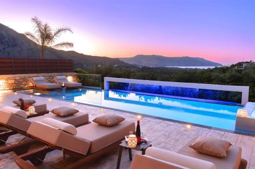 a villa with a swimming pool at sunset at Minoas Villas Heated Pool in Kournás