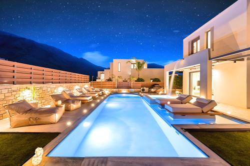 a villa with a swimming pool at night at Minoas Villas Heated Pool in Kournás