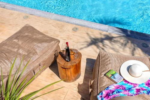 a bottle of wine in a bucket next to a pool at Minoas Villas Heated Pool in Kournás