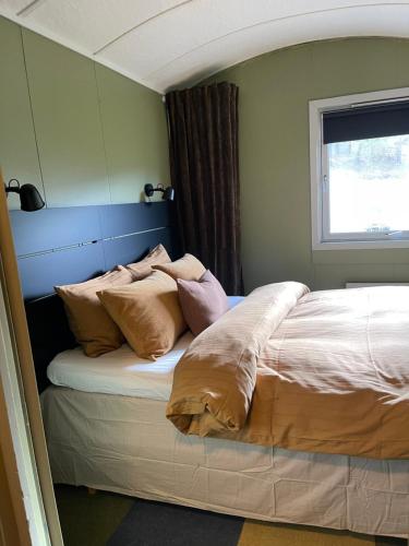 a bed with pillows on it in a bedroom at Koselig gårdshus in To