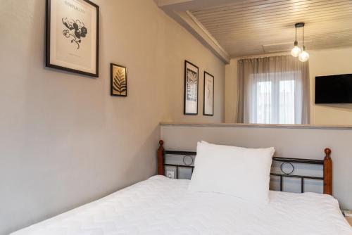 a bedroom with a bed and a tv on the wall at Burnelia Vacation Maisonette in Lefkímmi