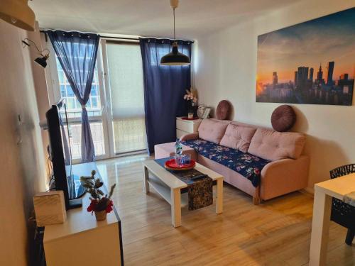 華沙的住宿－Apartament Centrum Jana Pawła II，客厅配有沙发和桌子
