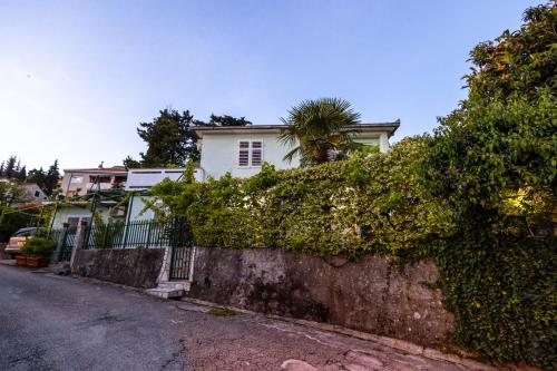 a white house with a palm tree on top of a wall at Apartmani Bijelic HN in Herceg-Novi