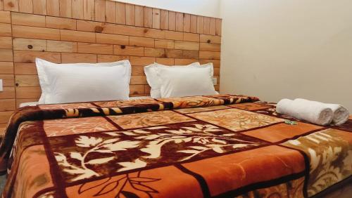 a bedroom with a large bed with a wooden headboard at Kavyansh Forest Valley in Dalhousie