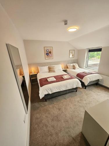 a bedroom with two beds and a window at Tatlers Guest House in Roscommon