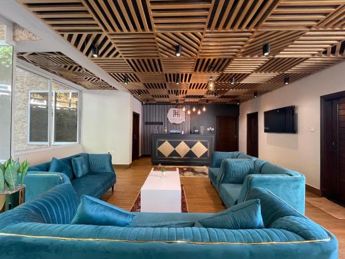 a living room with blue couches and a television at Hamdan Hotel and Resort in Murree