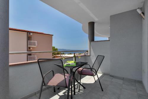 a balcony with a table and chairs and a view of the ocean at Villa Juric 1 in Baška Voda