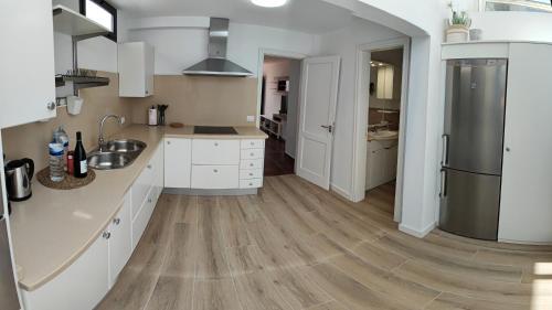 eine Küche mit weißen Schränken und einem Holzboden in der Unterkunft Casa Remo in Playa Honda