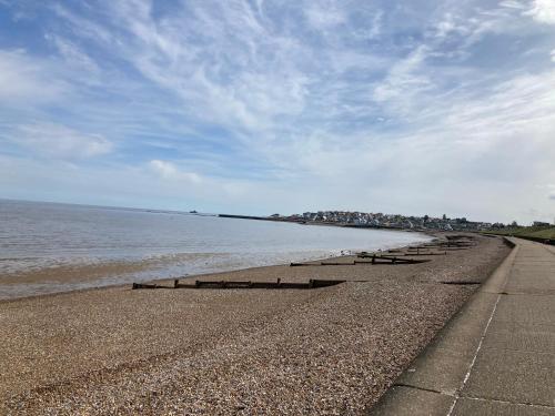 a row of benches on a beach next to the water at Seaview Holiday Rentals - Seawall in Whitstable