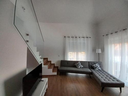 a living room with a couch and a staircase at AL Encanto in Grândola