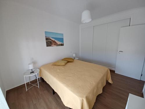 een slaapkamer met een bed in een witte kamer bij AL Encanto in Grândola