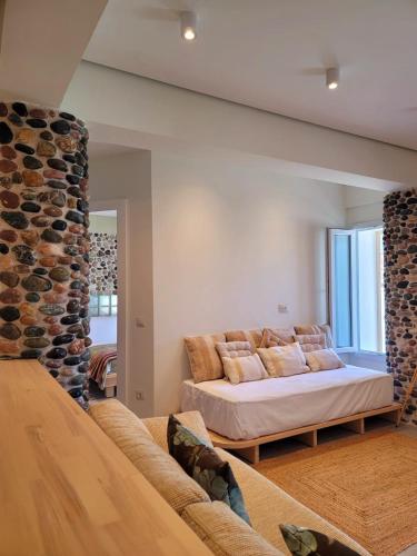 a living room with a bed and a stone fireplace at Artis Blue Relax in Himare